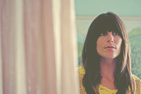 Woman with long hair, partially obscured curtain.