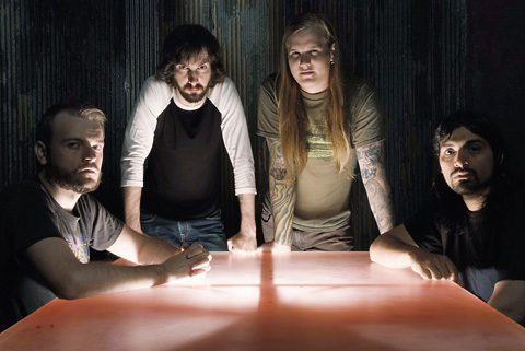 Band members gathered around a glowing table.