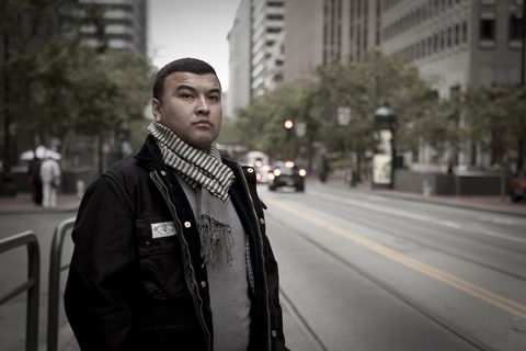 Man standing on city street in scarf.