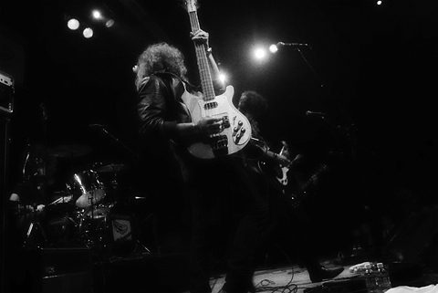 Rock band performing on stage with instruments.