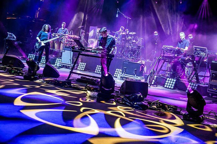 Live band performing on colorful illuminated stage.