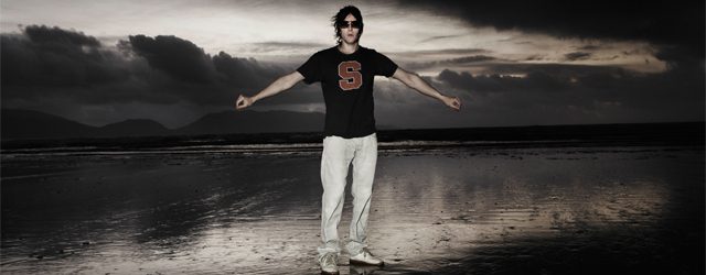 Person standing on beach at dusk.