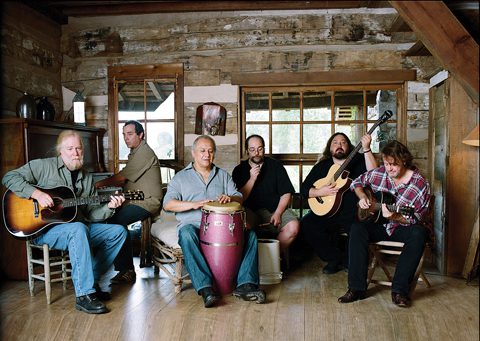 Band playing instruments in a rustic room.