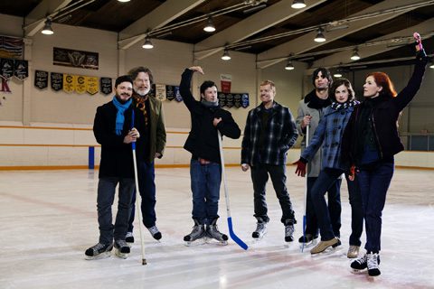 Group of people posing on ice rink.