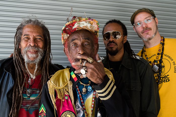 Four men posing with colorful attire.