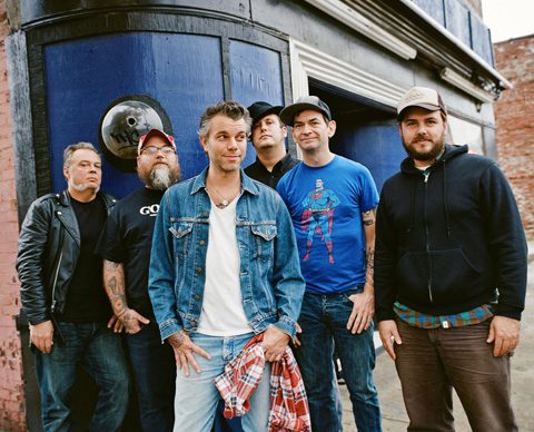 Group of six men standing outdoors.