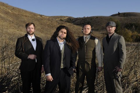 Four men in suits standing outdoors.