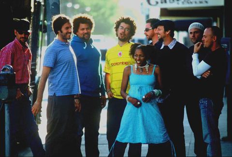 Group of people smiling outdoors on street.