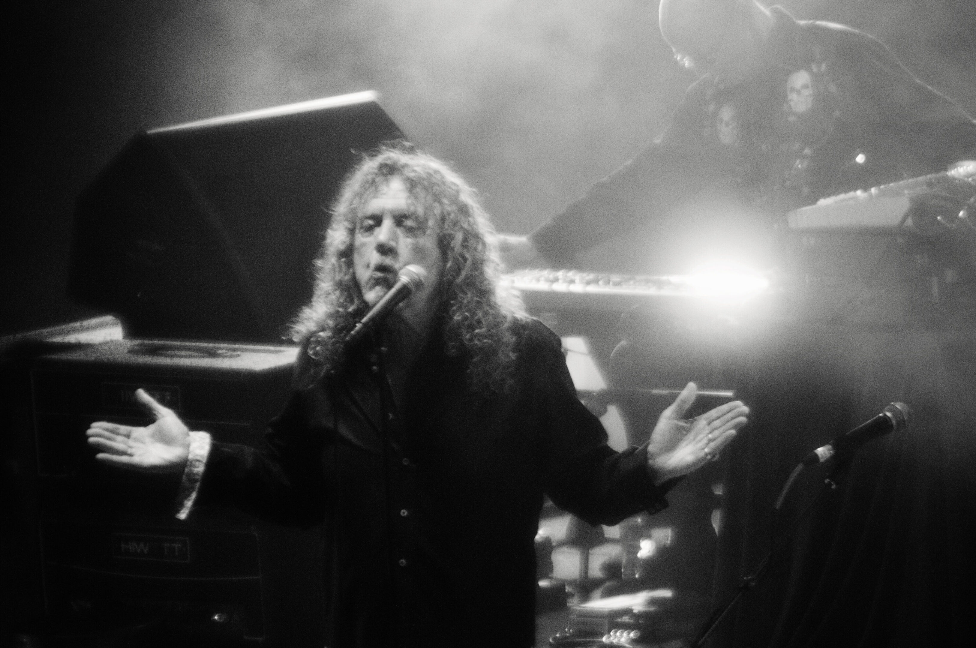 Singer performing on stage with keyboardist.