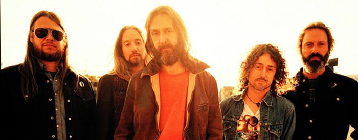 Five men standing in warm sunlight.