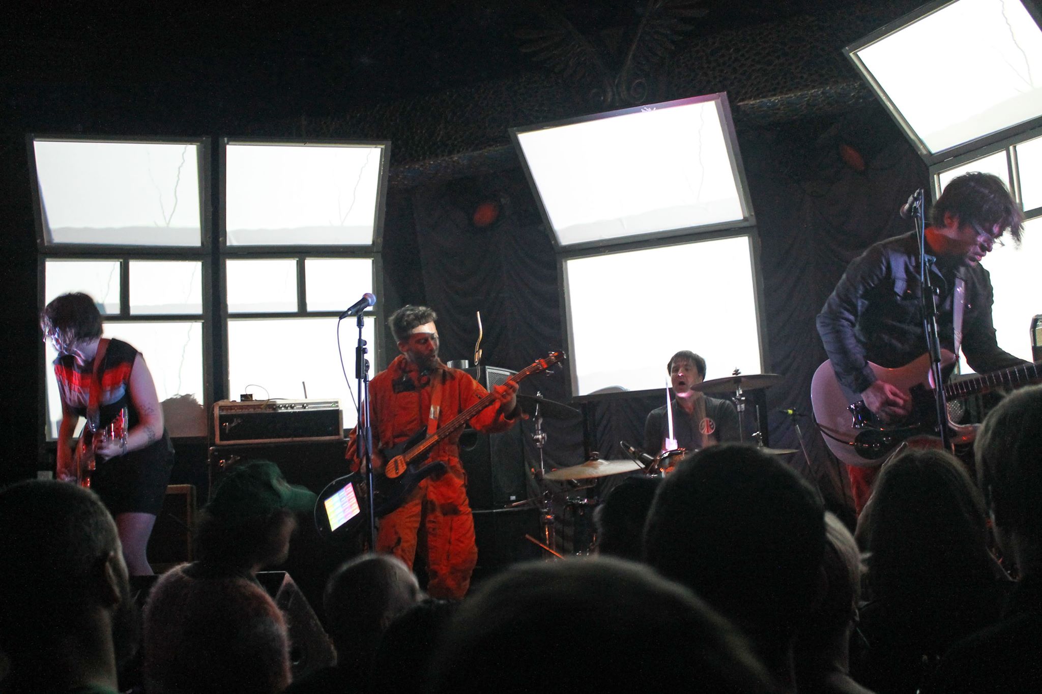 Band performing on stage in dim lighting.