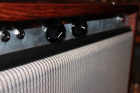 Guitar amplifier with control knobs and grille.