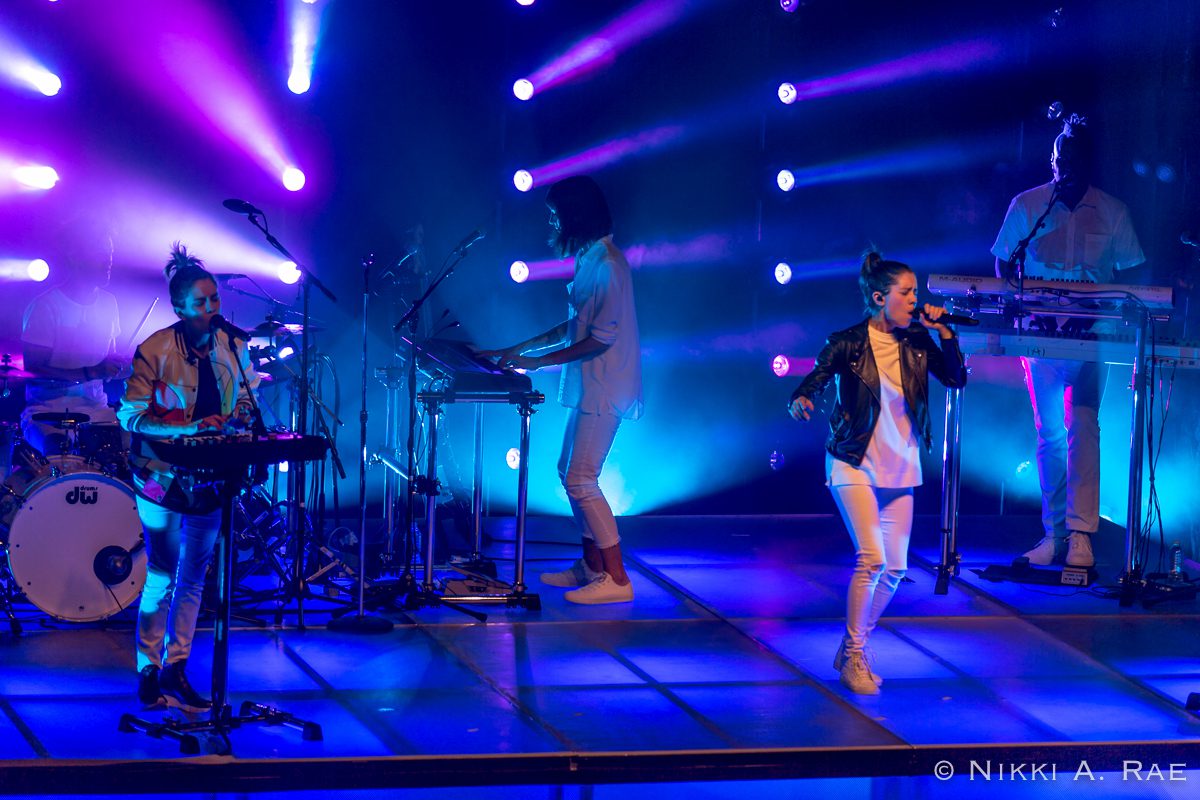 Band performing on stage with colorful lights.