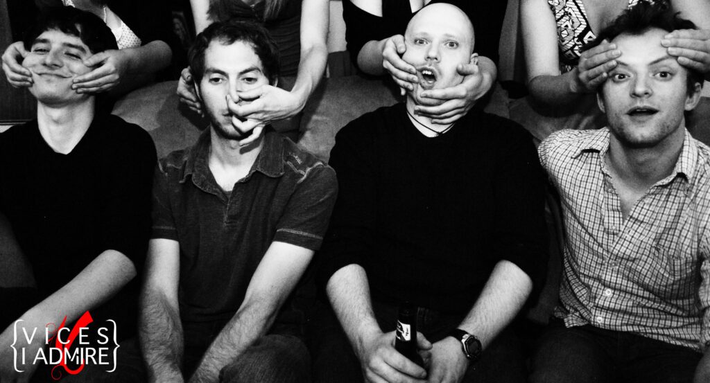 People posing with hands covering faces, smiling.