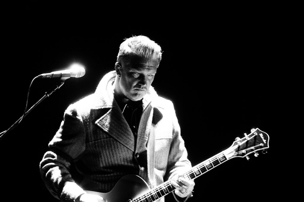 Guitarist performing on stage in black and white.