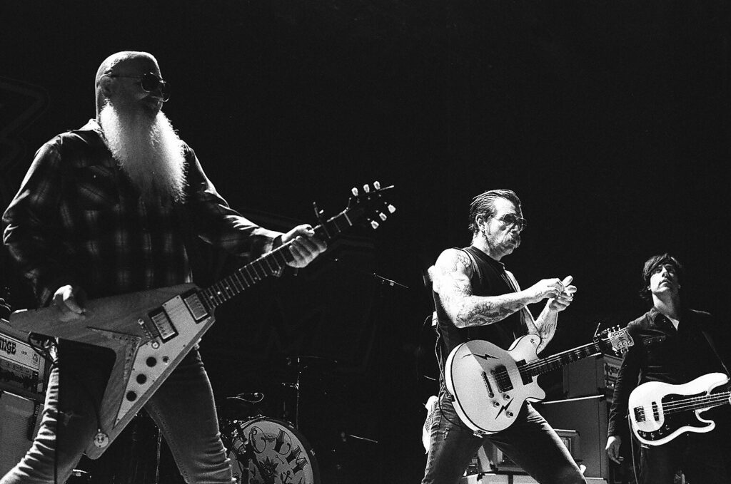 Rock band performing energetically on stage.