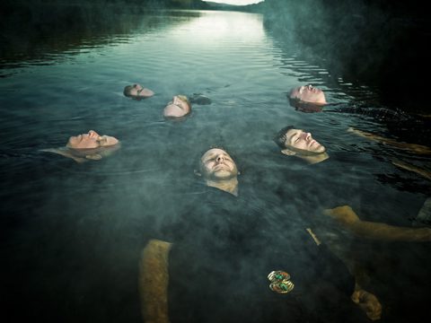 People floating in a misty lake.