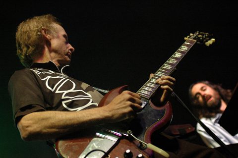 Guitarist playing passionately on stage.