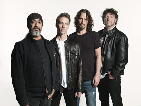Four men in leather jackets posing together.