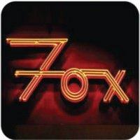 Neon sign spelling "Fox" in orange.