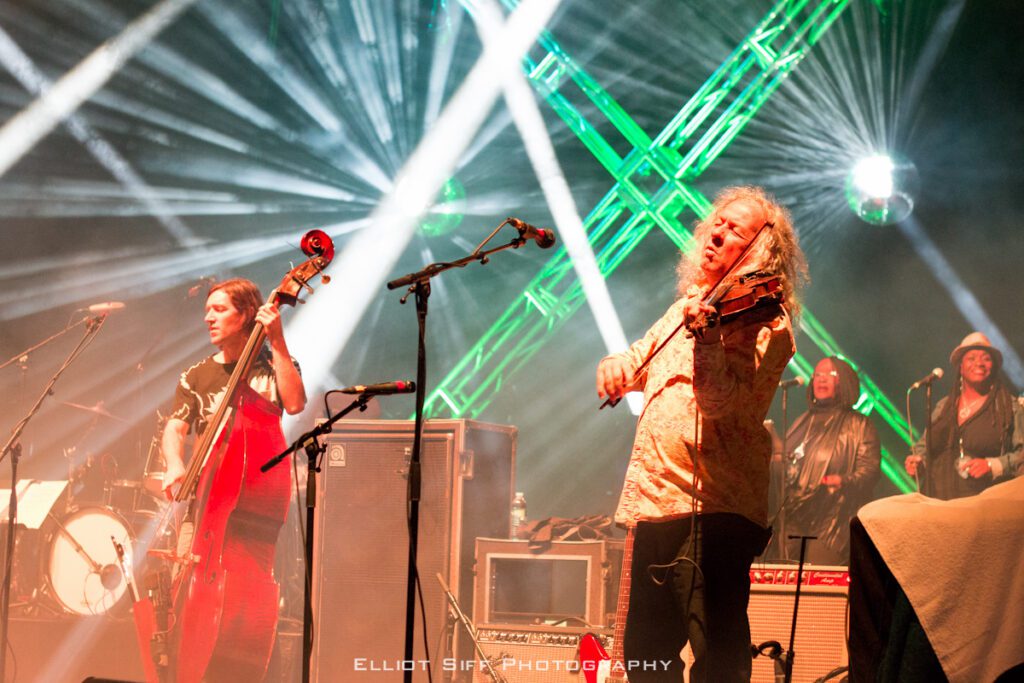 Musicians performing on stage with colorful lights.