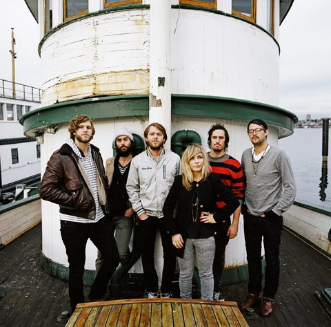 Band posing on a boat deck.