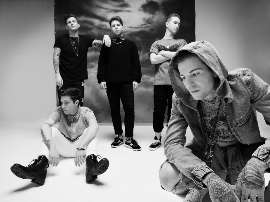 Five people posing in a studio setting.