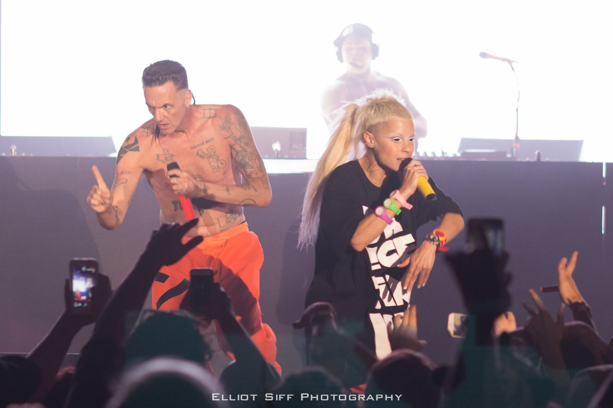 Performers on stage with microphones, vibrant atmosphere.