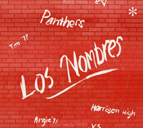 Red brick wall with graffiti-style text.