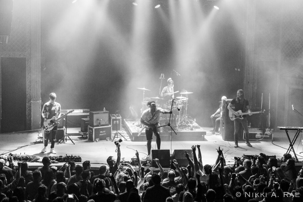 Band performing on stage with audience cheering.