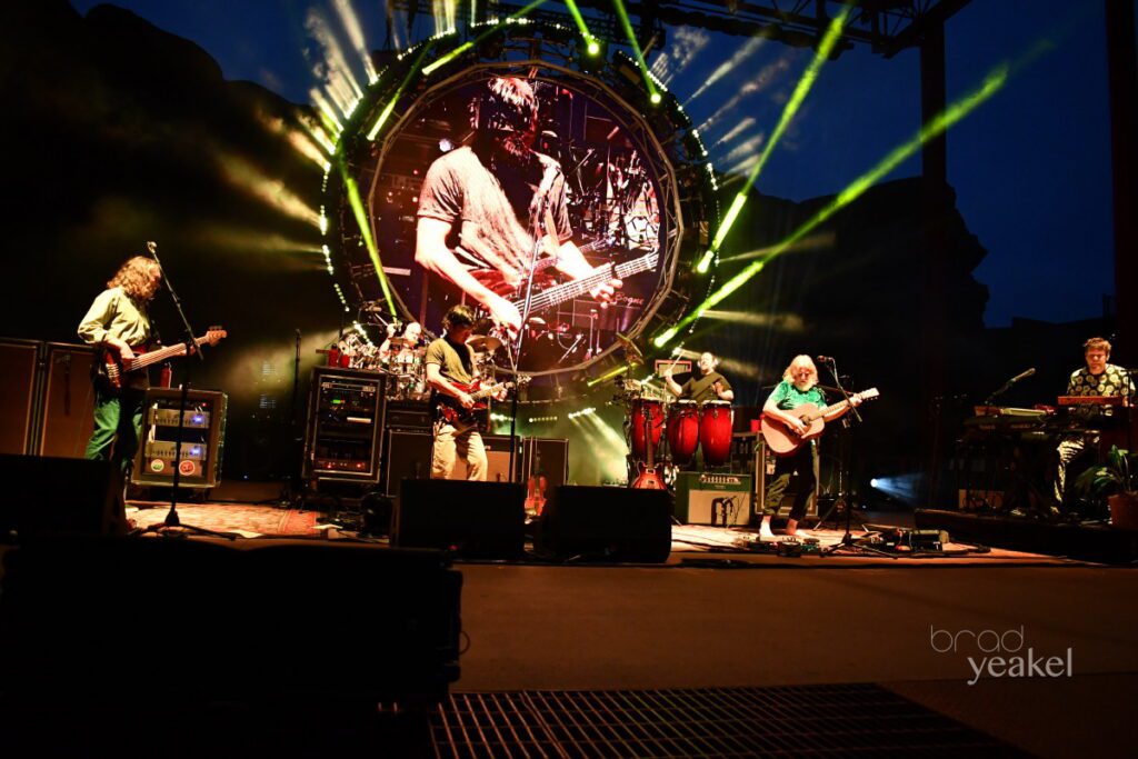 Band performing on stage with vibrant lights.