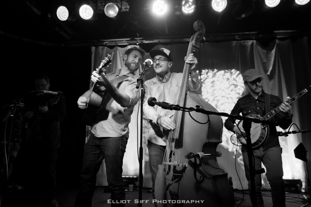 Band performing on stage with string instruments.