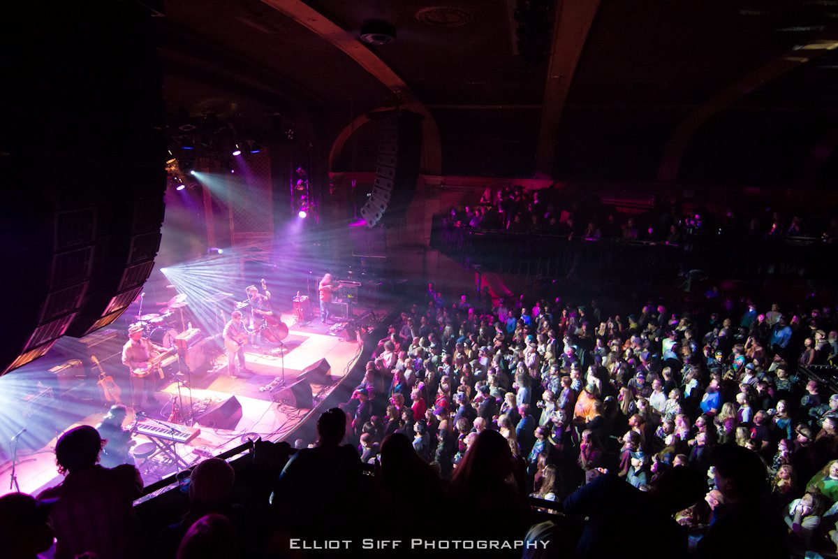Concert crowd enjoying live band performance.