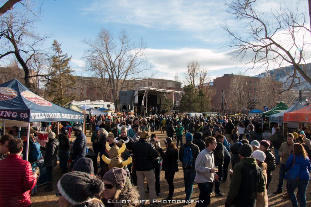 Outdoor festival with crowd and stage setup.