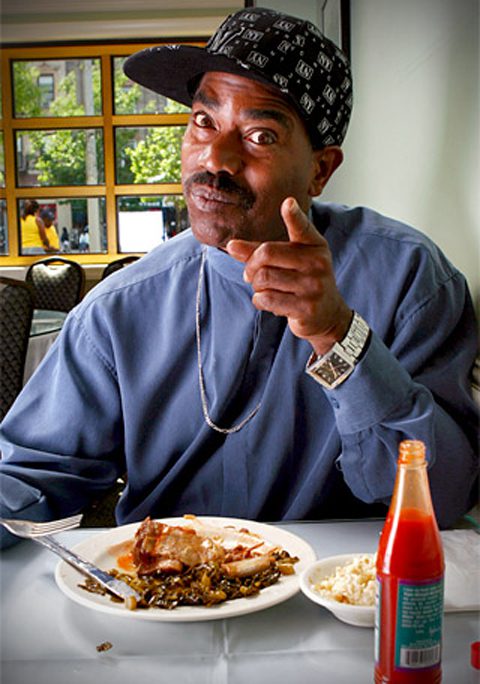 Man pointing while eating a meal.