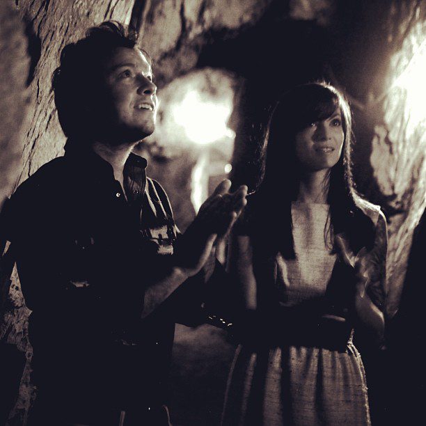 Two people in a dimly lit cave.