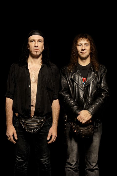 Two men in black leather outfits.