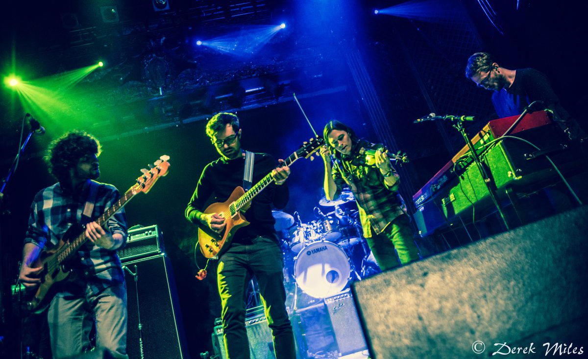 Band performing live on stage with instruments.