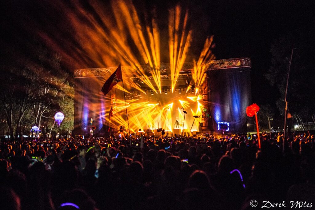 Outdoor concert with vibrant stage lights.