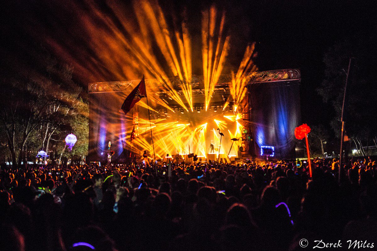 Outdoor concert with vibrant stage lights.
