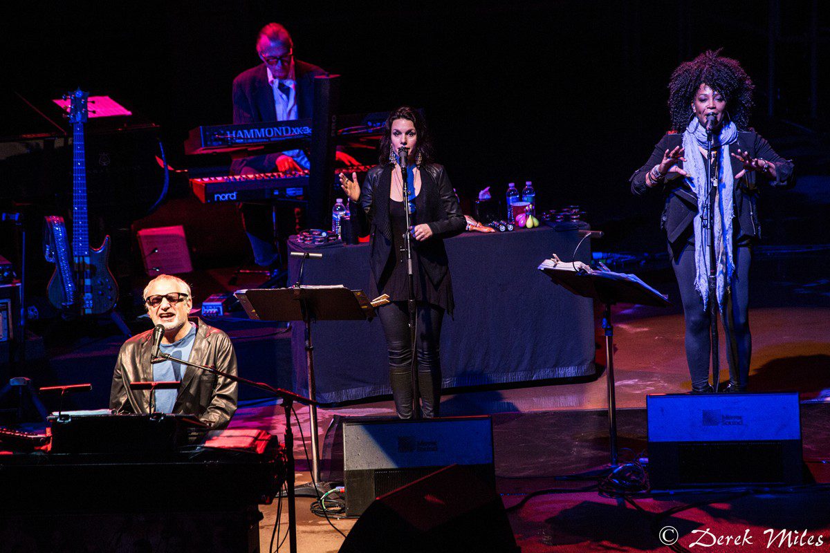 Musicians performing on stage with instruments.