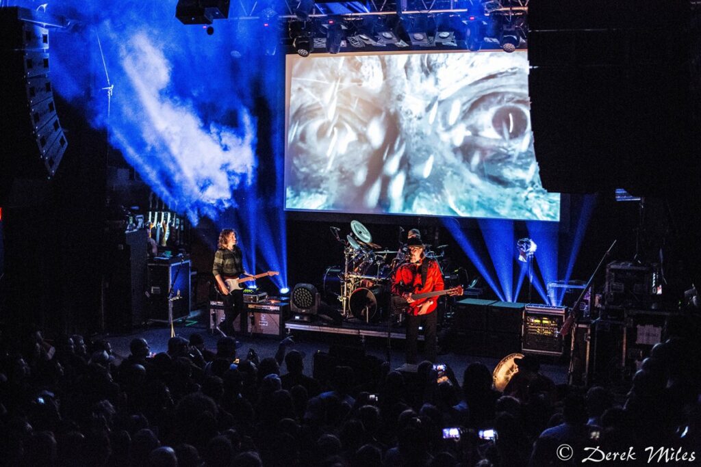 Band performing on stage with visual effects.