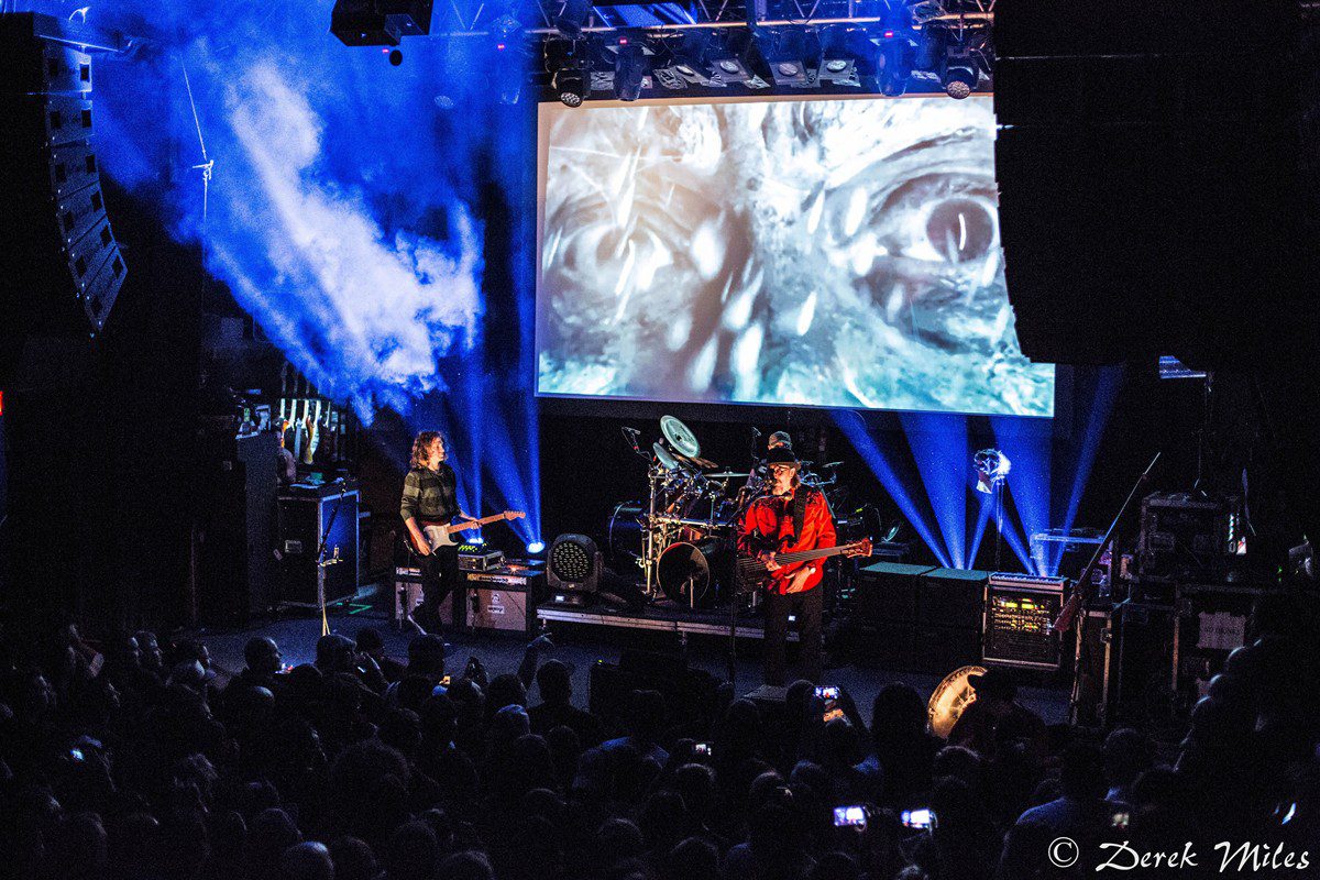 Band performing on stage with visual effects.