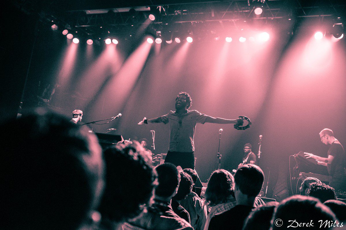 Concert performer with tambourine on stage.