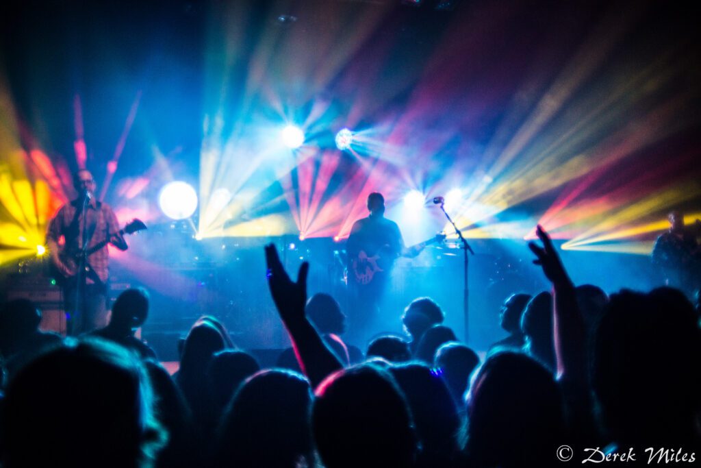 Concert with colorful stage lights and crowd.