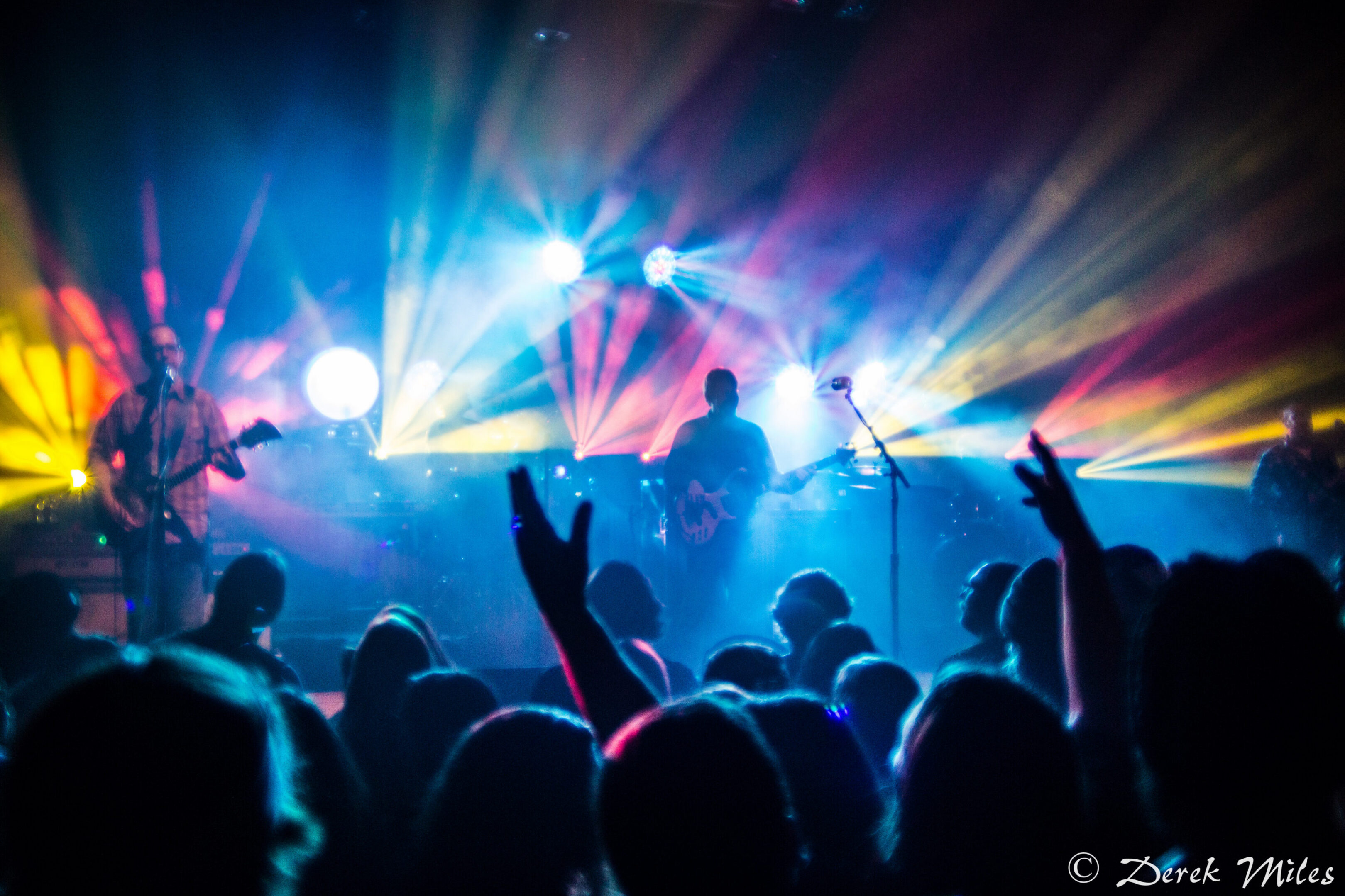 Concert with colorful stage lights and crowd.