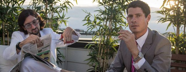 Two men in suits on a terrace.