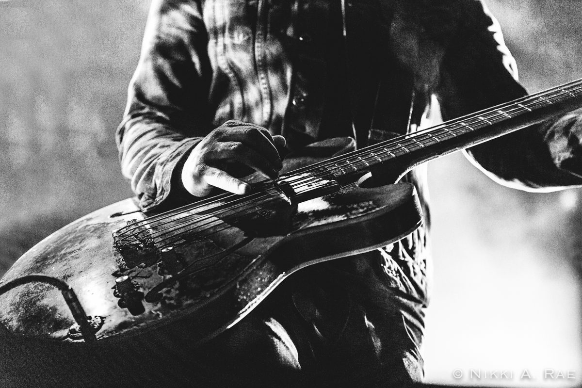 Musician playing electric guitar on stage.