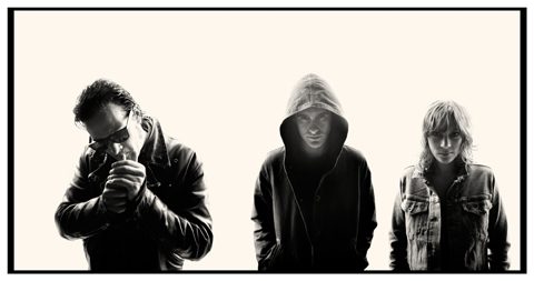 Three people in dark, silhouetted attire.