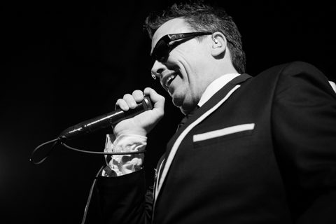 Singer performing on stage with microphone.